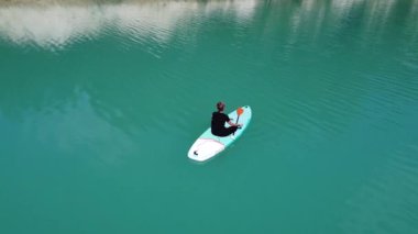 Kız göletteki salgı bezlerinde yoga yapıyor. Kamera etrafta uçuyor. Hava fotoğrafçılığı