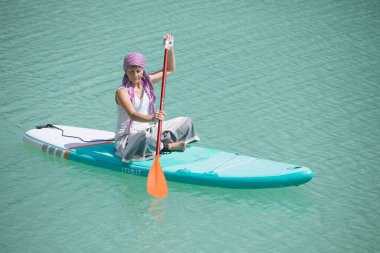 Kız göletteki salgı bezlerinde yoga yapıyor.