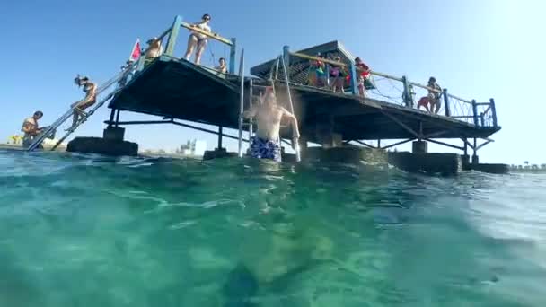 Personnes plongeant sous l'eau chaude cyan . — Video