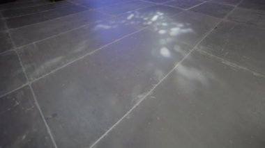 Parlak dönen yansımalar soğuk zemine dağılır ve ışık deseni oluşturur. Konser ayarları başlamadan önce teçhizat testinin sonuçları.