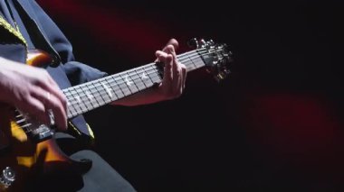 Yetenekli gitarist yakın plan gece kulübünde sahnede rock müzik çalıyor. Erkek müzisyen festival konserinde tek başına elektrikli enstrüman çalıyor.