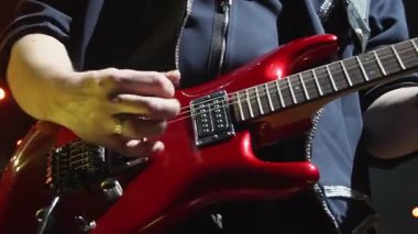 Kırmızı bas gitarlı müzisyen gece kulübünün yakın çekimlerinde müzikal gösterisine katılıyor. Tutkulu adam sahnede enstrümanla yeni bir şarkı söylüyor.