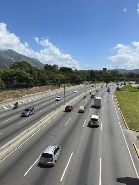 Caracas, Venezuela 'da yoğun otoyol trafiği, Güneşli bir günde arka planda El vila Dağı manzarası
