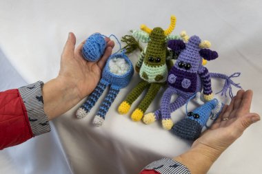 Amigurumi bebeği bir kadının ellerinde..