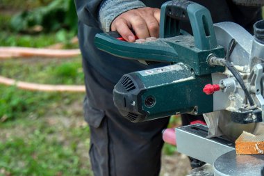 Tahtayı dairesel testere ile çevirip buduyor..