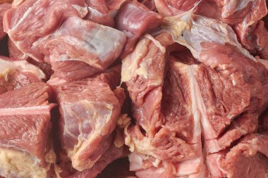 Yığının içinde çiğ kemiksiz kırmızı et parçaları, beyaz doku ile nemli lifli yüzey ve tam çerçeve dokusunda yağ, üst görünüm yakın plan, aşçılık ve kasap pazarlama kavramı