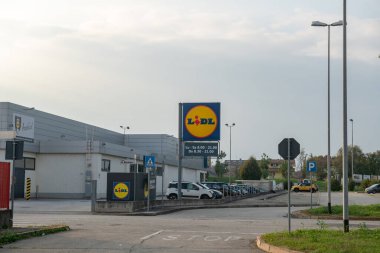 Reklam panosunda Lidl logosu, uluslararası bir süpermarketin sembolü, şimdi küresel bir perakende zinciri, gıda ve diğer ürünler satan ticari bir hipermarket. Büyük ölçekli perakende mağazaları indirim ve tatil anlaşmaları sunuyor ve yakında satışa açılacak. Web Haberleri