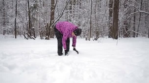 Gelukkig meisje plaing met een sneeuwpop op een besneeuwde winter lopen — Stockvideo