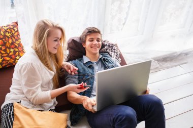 Genç çift dizüstü bilgisayara bakıyor.