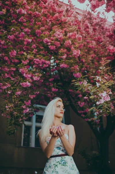 Beautiful blond girl in garden — Stock Photo, Image