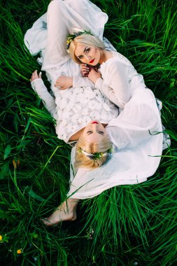 ikiz kız kardeşler yeşil çim üzerinde yalan