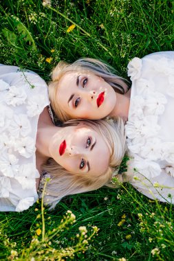 ikiz kız kardeşler yeşil çim üzerinde yalan