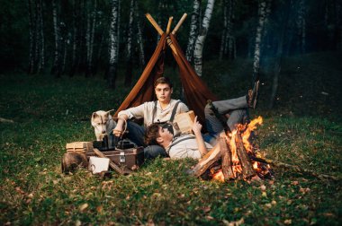 bir kamp ateşi etrafında oturan iki ikiz kardeşler