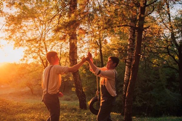 Twin brotherson swing — Stockfoto