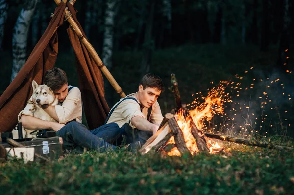 Dwóch braci bliźniaków, siedząc przy ognisku — Zdjęcie stockowe