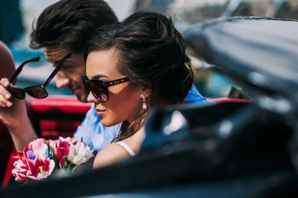 Pareja joven en coche vintage — Foto de Stock