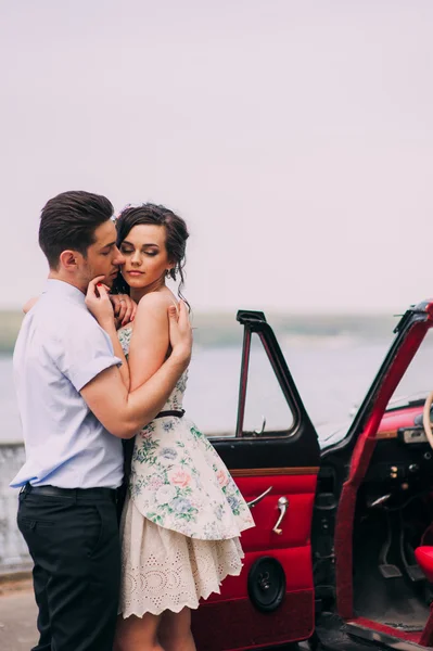 Pareja joven en coche vintage — Foto de Stock