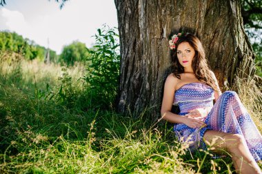 Kız yaşlı ağaç yakınındaki çimenlikte poz
