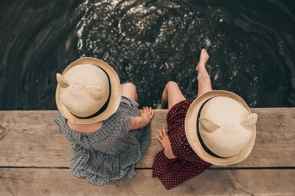Молодые девушки окунают ноги в озеро — стоковое фото