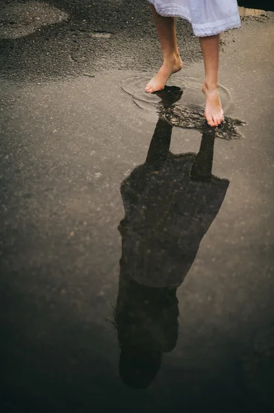 Mujer caminando descalza a través del charco — Foto de Stock