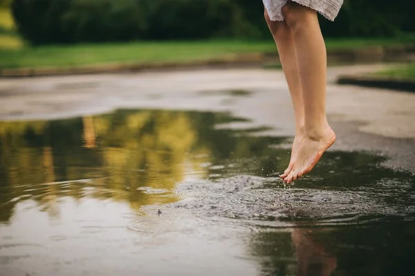 Жінка ходить босоніж крізь калюжу — стокове фото