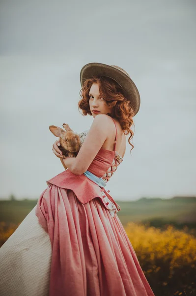 Красивая рыжая девушка с кроликом — стоковое фото