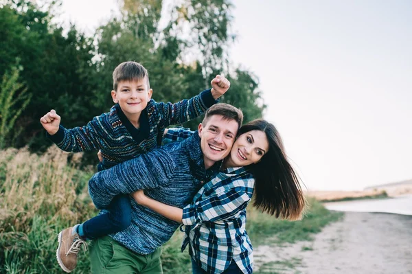 young family posing near the lake