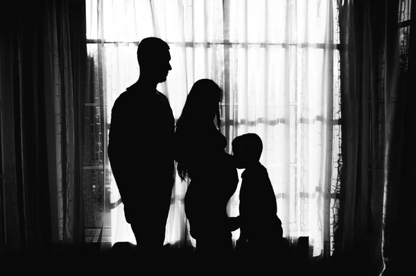 Aile ile hamile bir kadın siluetleri — Stok fotoğraf