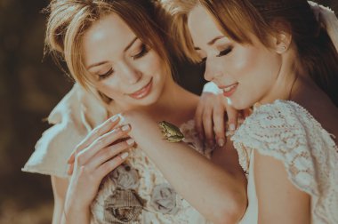 twinisters holding yeşil kurbağa elinde