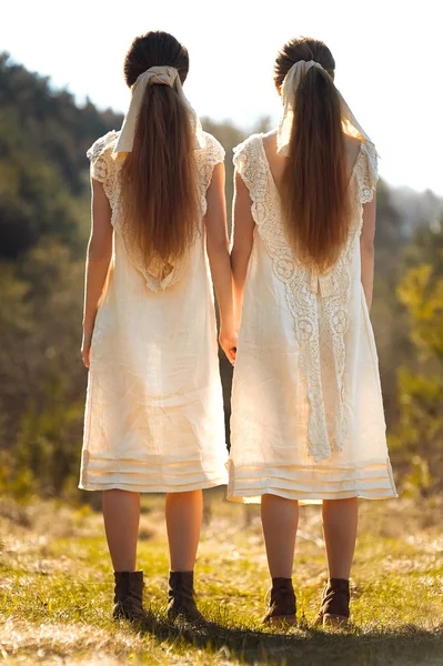 Две сестры-близнецы на лавке — стоковое фото