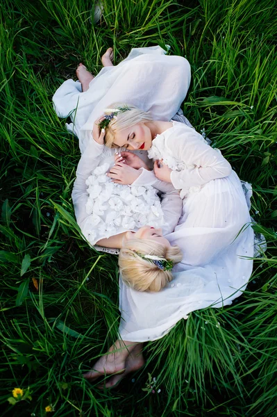 Hermanas gemelas tumbadas sobre hierba verde —  Fotos de Stock