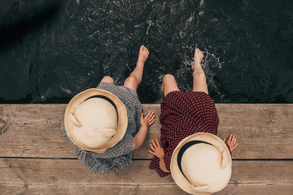 Meninas jovens mergulhando pés no lago — Fotografia de Stock