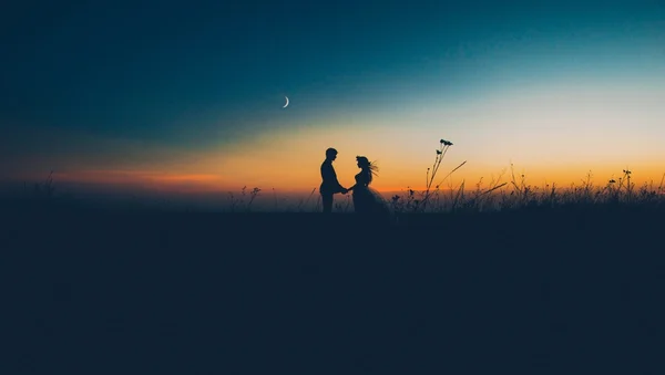 Silhouettes of couple at sunset Stock Image