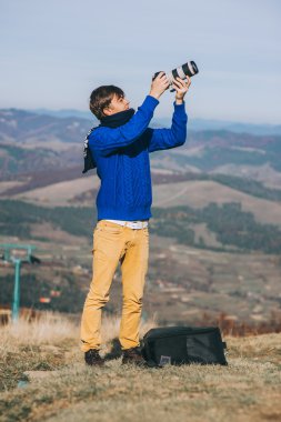 Bir uçurumun kenarında bir kamera ile adam