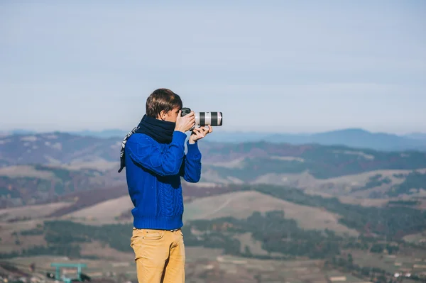 Man with a camera at the edge of a cliff — Stock Photo, Image