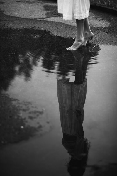 Woman walking barefoot through puddle