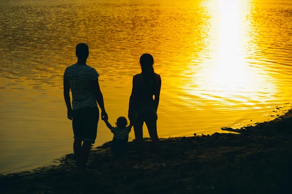 Ευτυχισμένη οικογένεια μαζί στο ηλιοβασίλεμα — Φωτογραφία Αρχείου