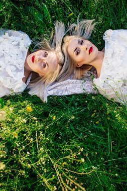 ikiz kız kardeşler yeşil çim üzerinde yalan