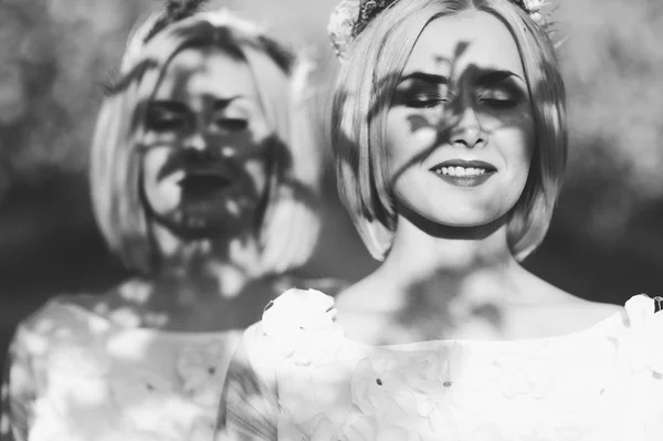 Two twin sisters in a cherry blossom — Stock Photo, Image