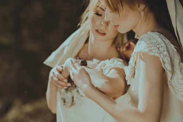 Twinisters holding grön groda i händer — Stockfoto