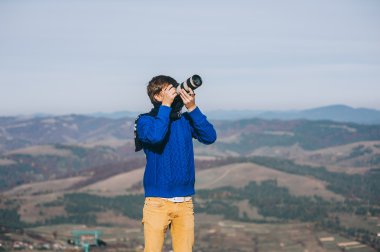 Bir uçurumun kenarında bir kamera ile adam