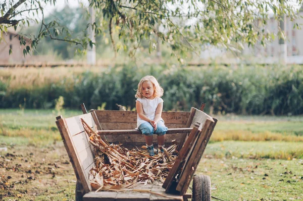 Menina sentado em um velho vagão de madeira — Fotografia de Stock