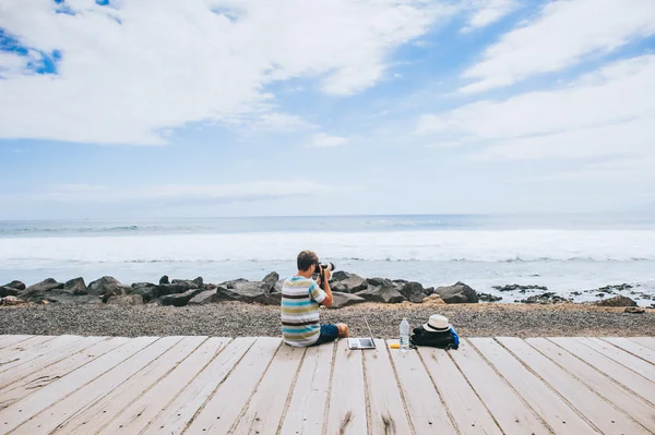 Joven fotógrafo trabajando con el ordenador portátil — Foto de Stock