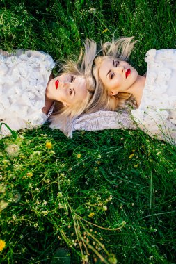 ikiz kız kardeşler yeşil çim üzerinde yalan