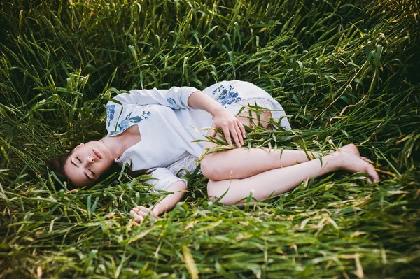 Молодая девушка лежит на пшеничном поле — стоковое фото