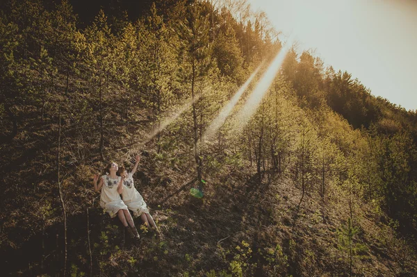 Två blonda tvillingsystrar i skogen — Stockfoto