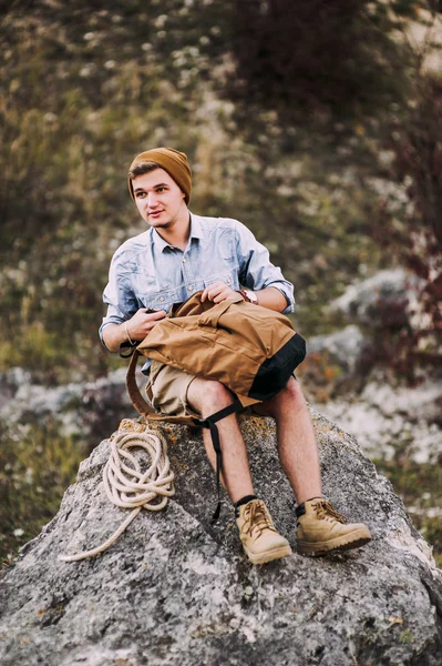 Jovem caminhante homem abrindo sua mochila — Fotografia de Stock