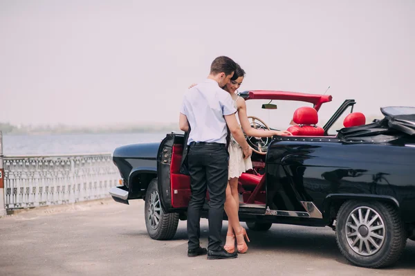 Jovem casal com carro vintage — Fotografia de Stock