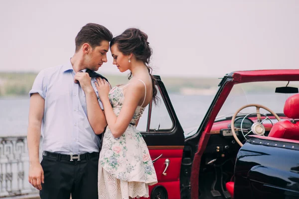 Jeune couple avec voiture vintage — Photo