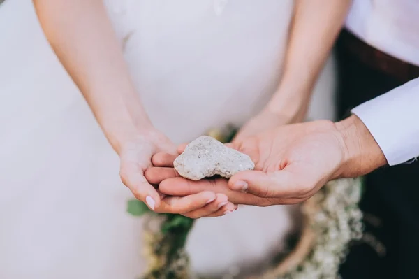 Manos sosteniendo una piedra en forma de corazón — Foto de Stock